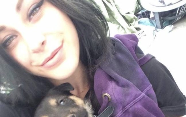 Kayla smiling, holding a puppy close