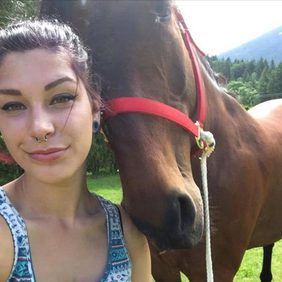 Kayla smiling next to a horse